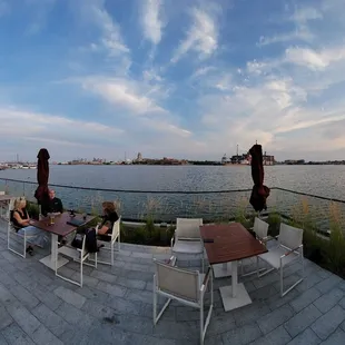 people sitting at tables overlooking the water