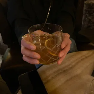 a person holding a glass of alcohol