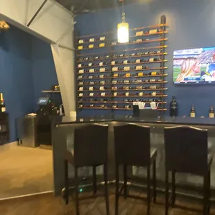 a bar with chairs and a television