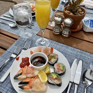 a plate of sushi and a glass of orange juice