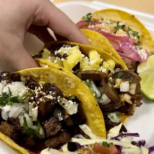 a hand grabbing a taco