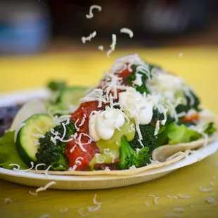 a plate of broccoli, tomatoes, and cheese