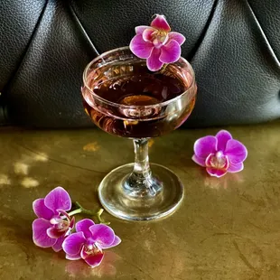 cocktail garnished with pink orchids at the carlile in downtown seattle