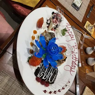 Birthday dessert sampling. Cheesecakes, bread pudding.. Don&apos;t mind the blue flower candle in the middle.