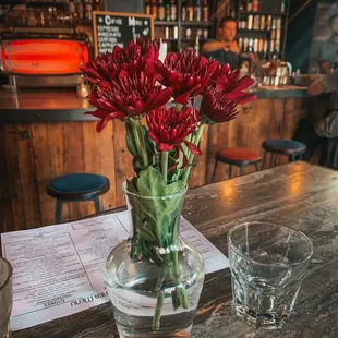 a vase of red flowers on a table