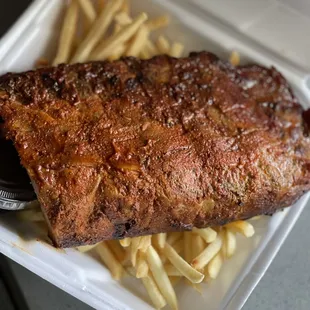 ribs and fries in a styrofoam container