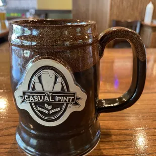 a brown mug with the casual pint logo on it