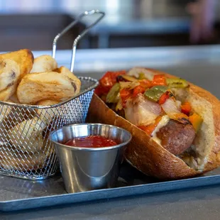 Drunken Brat.  Drizzled with housemade beercheese, housemade pepper &amp; onion mix, on locally sourced pretzel Bun.