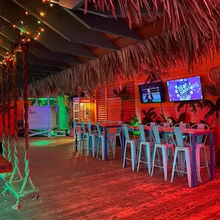 a bar with a tiki hut in the background