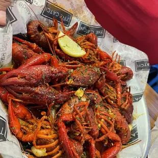 a plate of craws with a lemon wedge