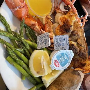 a plate of lobster, asparagus and potatoes