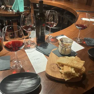 a table with wine glasses, cheese and crackers