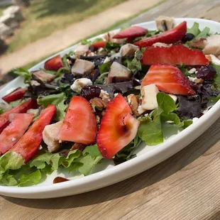 a salad with strawberries and chicken