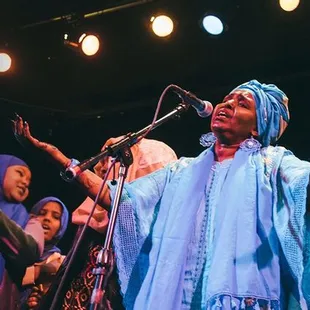 a group of people singing on stage