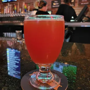 a glass of beer on a coaster