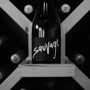 a bottle of sauvige in front of a wine rack