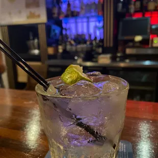 a gin cocktail with a lime garnish