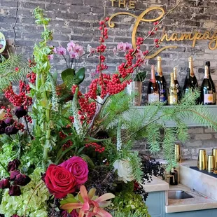 a vase of flowers and bottles of wine
