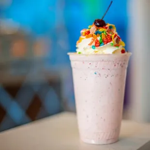 a milkshake with sprinkles and a cherry on top