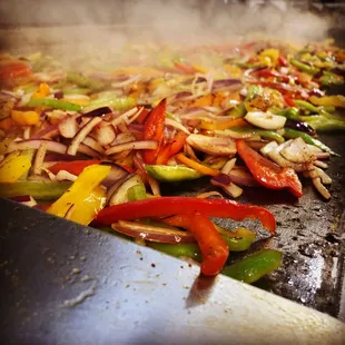 a mixture of vegetables cooking in a wok