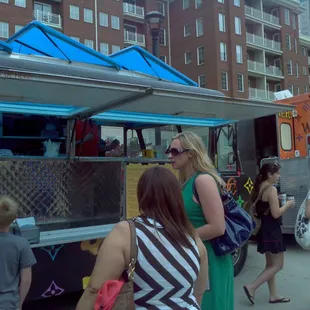 a group of people standing in front of a food truck
