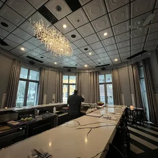 a kitchen with a long table and a chandelier