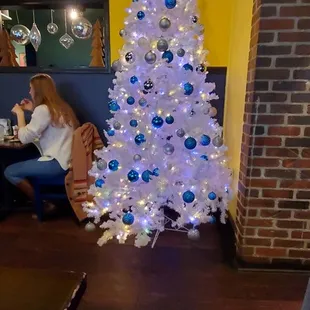 a white christmas tree with blue ornaments