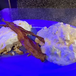 The Grant &quot;The Perfect Breakfast&quot; containing biscuits and gravy with slices of bacon and eggs over easy over hash browns