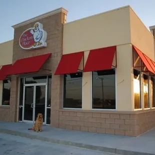 a dog sitting in front of the chicken place