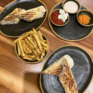 Chimichurri wrap, OG wrap, zaa&apos;tar fries and delicious sides of garlic, harrissa, a red pepper paste, and a aoili of some sort...yum!