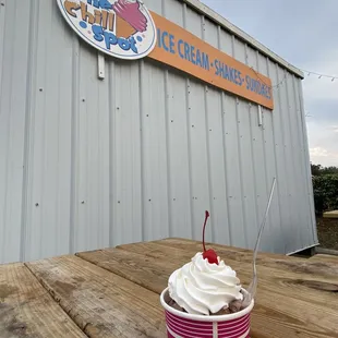 a cup of ice cream with a cherry on top