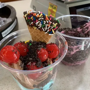 two ice cream sundaes with cherries and sprinkles