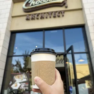 a hand holding a cup of coffee