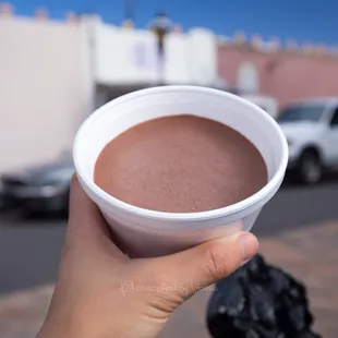 a hand holding a cup of hot chocolate