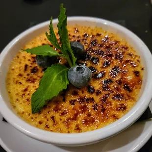 a bowl of creme with blueberries on top