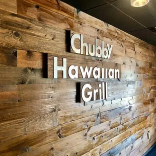 a wooden wall with a sign that says chubby hawaiian grill