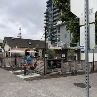 a person sitting on a bench in front of a restaurant