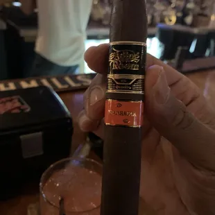 a hand holding a cigar