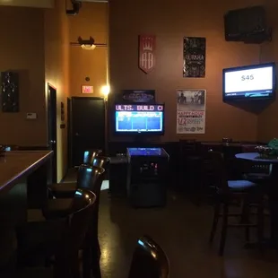 a bar with two televisions on the wall