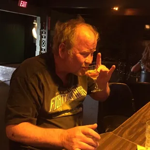 a man drinking a glass of wine