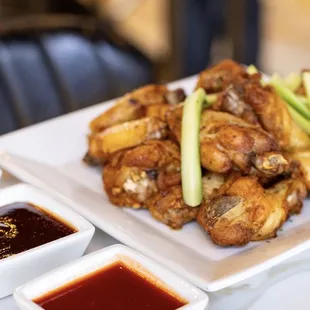 a plate of chicken wings and dipping sauces