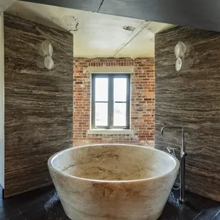 Enormous travertine tub in the master bathroom