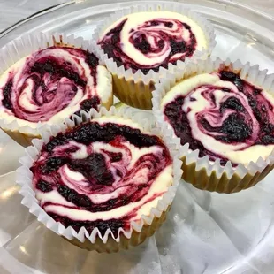 four cupcakes on a glass plate