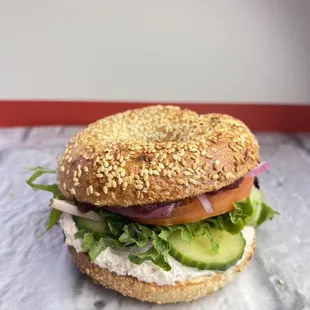 Veggie sandwich with hummus, cucumber, tomatoes, red onion, greens and smashed avocado.