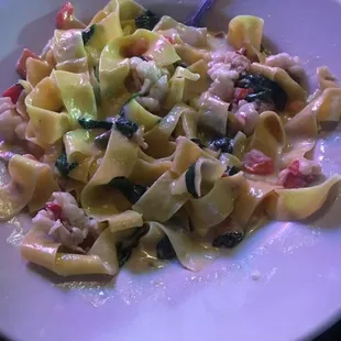 Fresh pasta with tomato, spinach, and chunks of lobster in a lobster sherry sauce