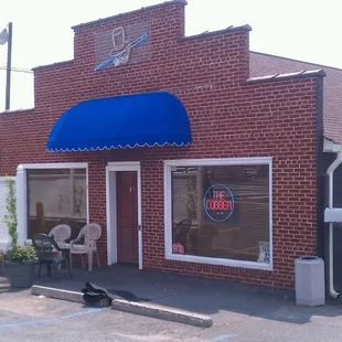 a brick building with a blue awning