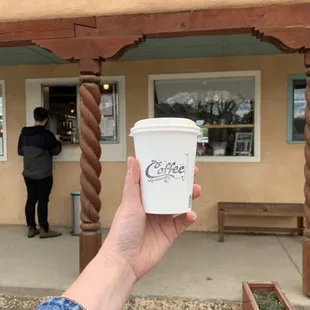 a hand holding a cup of coffee