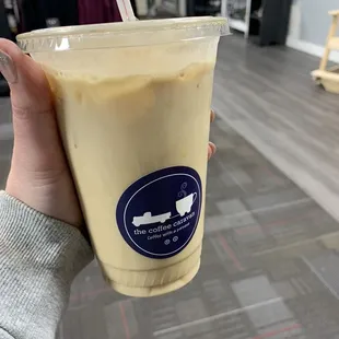 a hand holding a cup of iced coffee