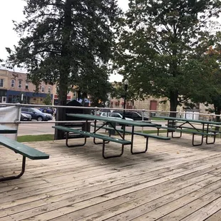 a row of picnic tables on a wooden deck