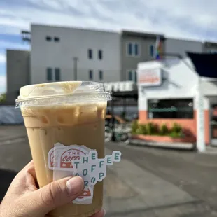 a hand holding a cup of iced coffee